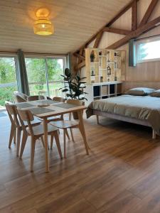 a bedroom with a bed and a table and chairs at ty loft keremma in Tréflez