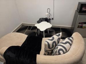 a couch with pillows on the floor in a room at Bibo cabins in Ruringʼu