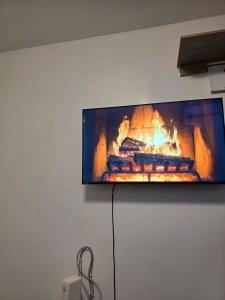 a flat screen tv hanging on a wall with a fireplace at Bibo cabins in Ruringʼu