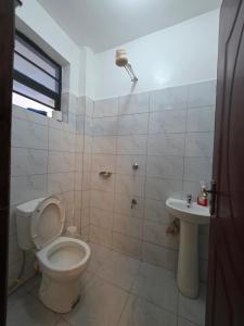 a bathroom with a toilet and a sink at Bibo cabins in Ruringʼu