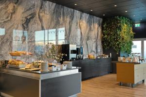 a restaurant with a counter with food on it at Hotel Vellir in Hafnarfjörður