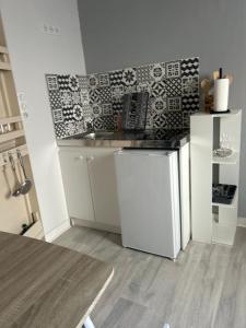 a small kitchen with a sink and a refrigerator at Chez Elie in Saintes