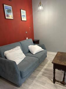 a living room with a blue couch and a table at Chez Elie in Saintes