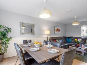 a dining room with a wooden table and chairs at Pink Blossom in Clifden