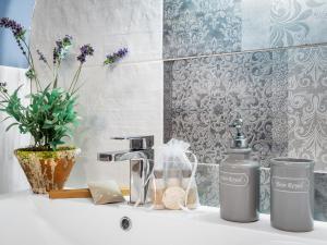 a sink with a faucet and a bottle of soap at Pink Blossom in Clifden +64 photos