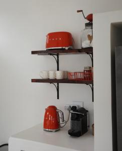 a kitchen with red appliances on a shelf at Huis Prins in Prince Albert