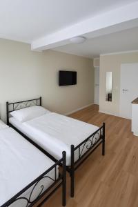 two beds in a room with a flat screen tv at My Loft in Hagen