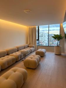 a large living room with couches and a large window at Adagio Quito Suite de Lujo in Quito