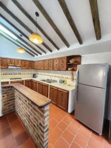 a kitchen with a white refrigerator and wooden cabinets at Apartamento de la Villa I in Villa de Leyva +7 photos