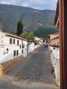 an empty street in a town with mountains in the background at Apartamento de la Villa I in Villa de Leyva