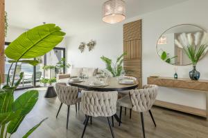 a dining room with a table and chairs and a mirror at Alma do mar luxury - Ocean front in Gaula +29 photos