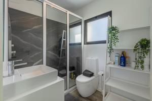 a bathroom with a toilet and a sink and a shower at Alma do mar luxury - Ocean front in Gaula