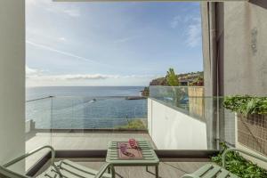 a balcony with a view of the ocean at Alma do mar luxury - Ocean front in Gaula