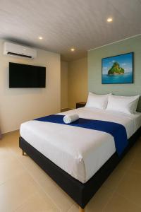a bedroom with a large bed with a flat screen tv at HOTEL COSTA AZUL SAI in San Andrés