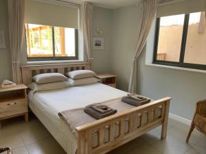 a bedroom with a bed with two towels on it at Desert Rose in Midreshet Ben Gurion +16 photos