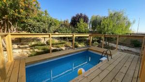 a swimming pool with a wooden deck and a fence at Desert Rose in Midreshet Ben Gurion