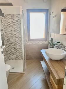 a bathroom with a sink and a glass shower at Waterfront apartment Olbia in Olbia +20 photos