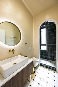a bathroom with a sink and a toilet and a mirror at Lithos Boutique Residences in Volos