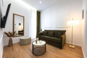 a living room with a couch and a mirror at Lithos Boutique Residences in Volos