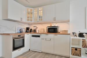 a kitchen with white cabinets and a microwave at Küstenkinder Whg 17 in Kellenhusen