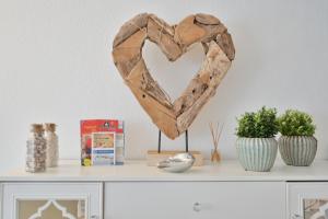 a wooden heart on top of a shelf at Küstenkinder Whg 17 in Kellenhusen +19 photos