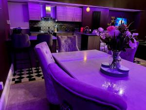 a purple dining room table with a vase of flowers on it at Hamilton Luxury - The James Suite in Scorton