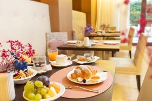 a table with plates of breakfast food on it at Laguna Palace Hotel Grado in Grado