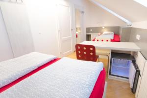 Kleines Zimmer mit 2 Betten, einem Schreibtisch und einem Tisch in der Unterkunft H2O Hostel in Ljubljana