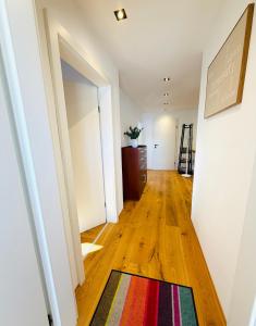 a hallway with a colorful rug on a wooden floor at dorfwerfen137 in Pfarrwerfen