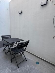 two chairs and a table in front of a wall at Casa Mía Hotel Boutique in Zamora de Hidalgo
