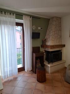 a living room with a fireplace and a window at Le Tre Civette in Alfedena