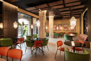 a restaurant with green and orange chairs and tables at Blanq Gran vía in Valencia
