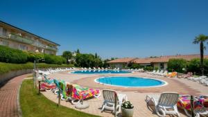 a group of chairs and a swimming pool at A casa di Attila DesenzanoLoft Official Partner Homes & Villas by Marriott Bonvoy in Desenzano del Garda
