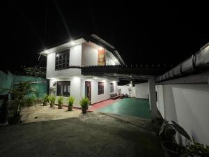 a night view of a white house with a courtyard at PINI ROO Villa in Badulla