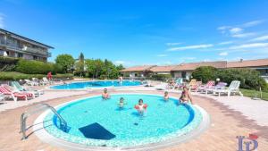 a group of people playing in a swimming pool at A casa di Attila DesenzanoLoft Official Partner Homes & Villas by Marriott Bonvoy in Desenzano del Garda