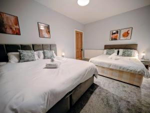 a bedroom with two beds with white sheets at 4, The Croft, Bellingham in Bellingham