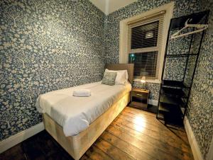 a bedroom with a bed with blue and white wallpaper at 4, The Croft, Bellingham in Bellingham