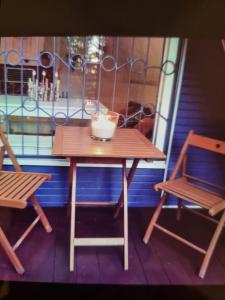 a table and chairs on a balcony with a candle on it at Abenteuerurlaub im Tannenwald in Ilmenau