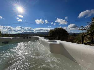 a bath tub filled with water with the sun behind it at Antracit House in Kismaros