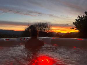 a woman sitting in a bath tub watching the sunset at Antracit House in Kismaros