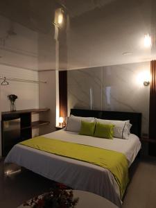 a bedroom with a large bed with green and white pillows at HOTEL LIGHT PLAZA in Aguachica