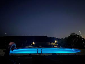 a large blue swimming pool at night at Casa Amnisty in Liubcova
