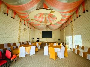 a conference room with tables and chairs and a screen at RJ Hotel Pokhara in Pokhara