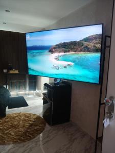 a flat screen tv on a wall with a beach on it at Suite San Giovanni in Gela