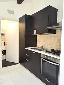 a kitchen with black cabinets and a stove at Residence Borghesi in Parma +9 photos