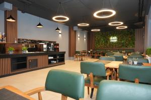 ein Restaurant mit Tischen, Stühlen und einer Bar in der Unterkunft E&B Hotel Korb bei Waiblingen & Stuttgart in Korb