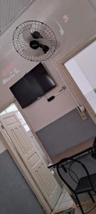 a desk with a computer keyboard and a fan at Hotel Cadore in Bauru