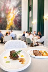 two plates of food on a table in a restaurant at Orion Palace Boutique Hotel in Durrës