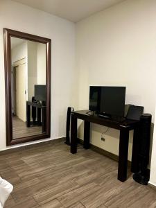 a room with a desk with a television and a mirror at LÁZARO D primer piso in Monterrey