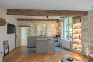 a kitchen with a stone wall and a kitchen island at Le Clos du XVIe - Exceptional accommodation in Orléans